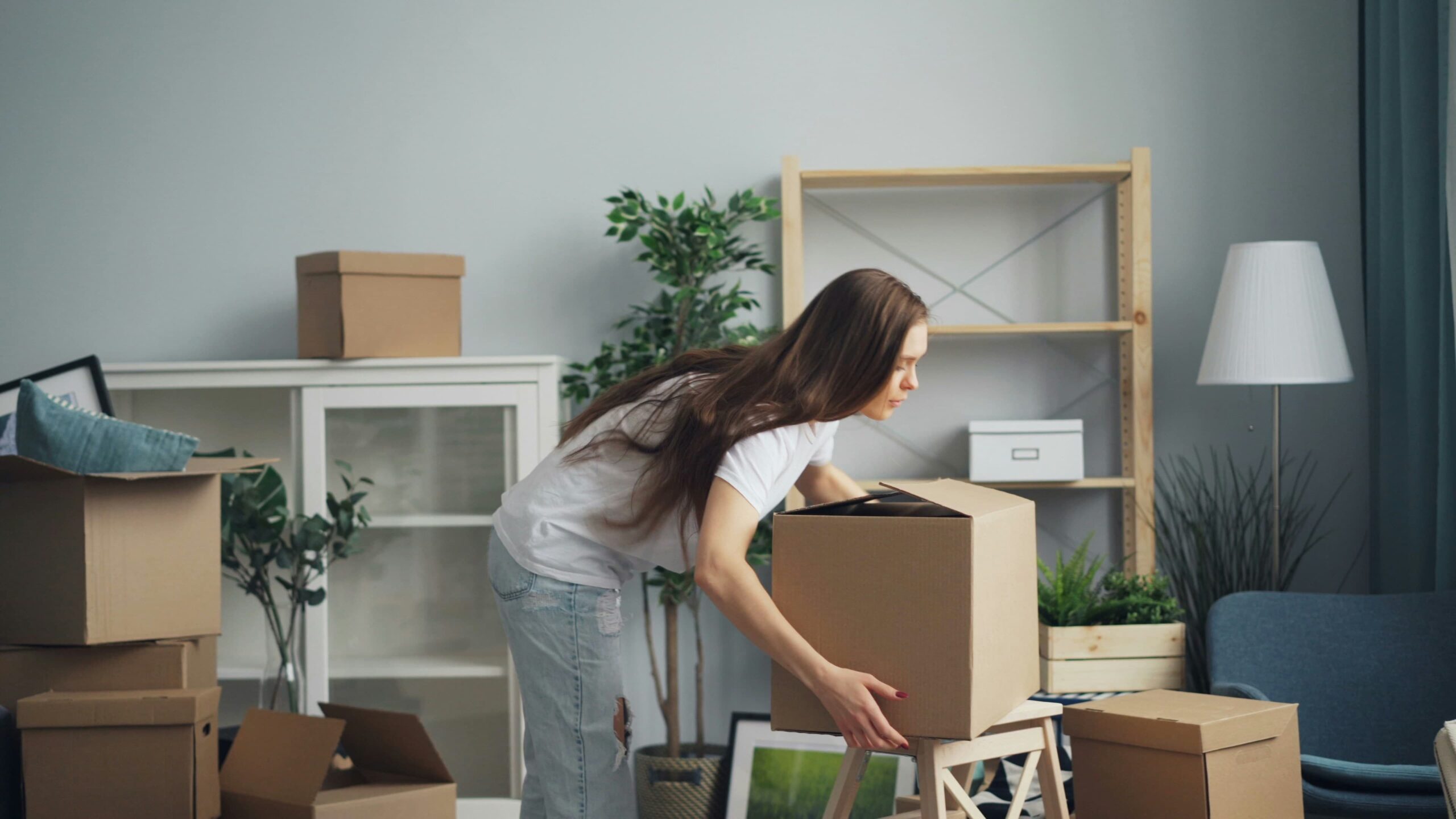 Woman packing a box with essentials for the first night in a new home