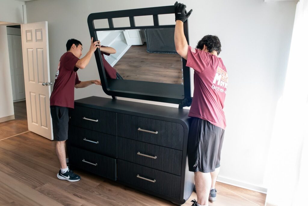 Better Call Moving crew reattaching a mirror to a dresser after delivery