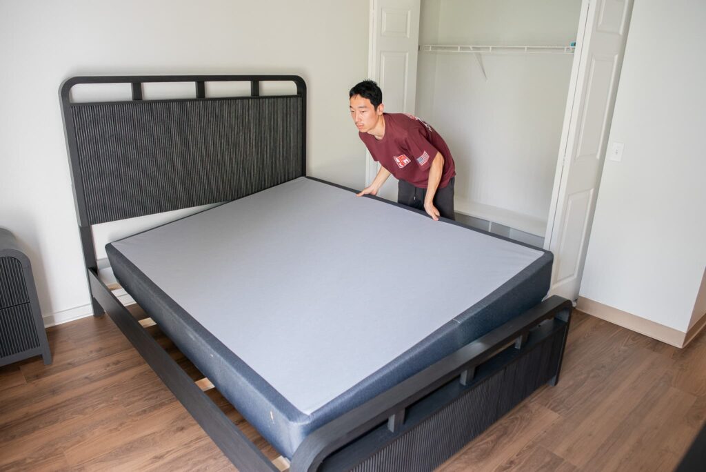 Better Call Moving crew setting up a bed frame in a bedroom of a new home