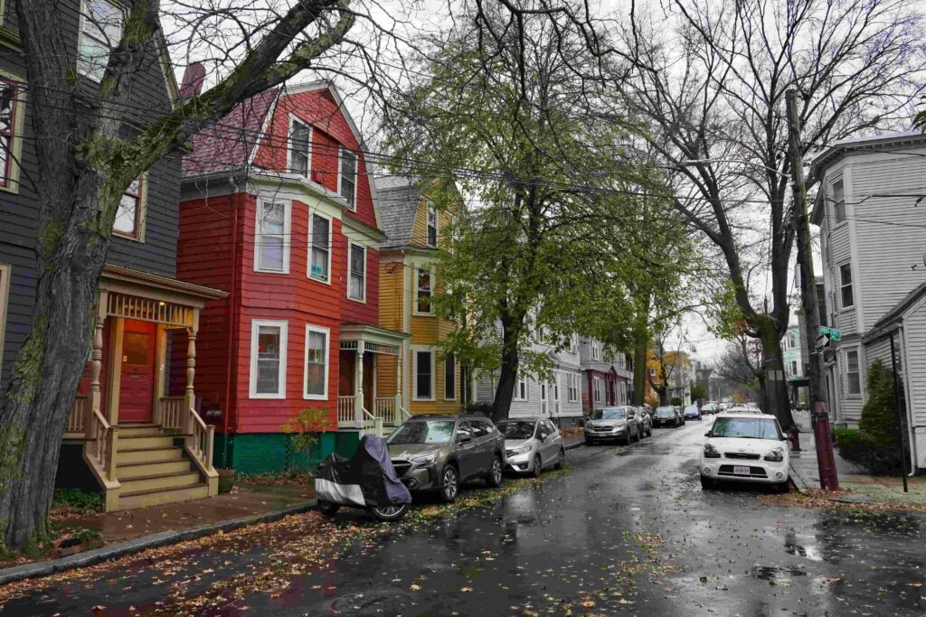 Older multi-family houses on a narrow one-way street in Cambridge, MA