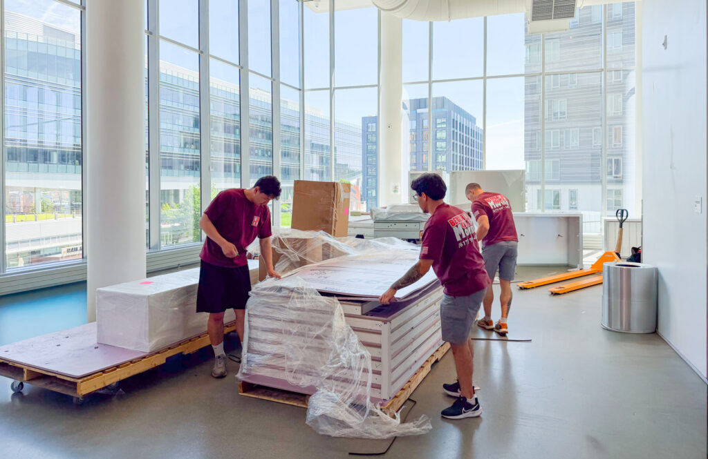 Better Call Moving crew preparing palletized items for a commercial move in a modern Boston office building