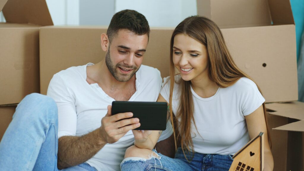 Couple comparing moving company estimates on a tablet before booking movers